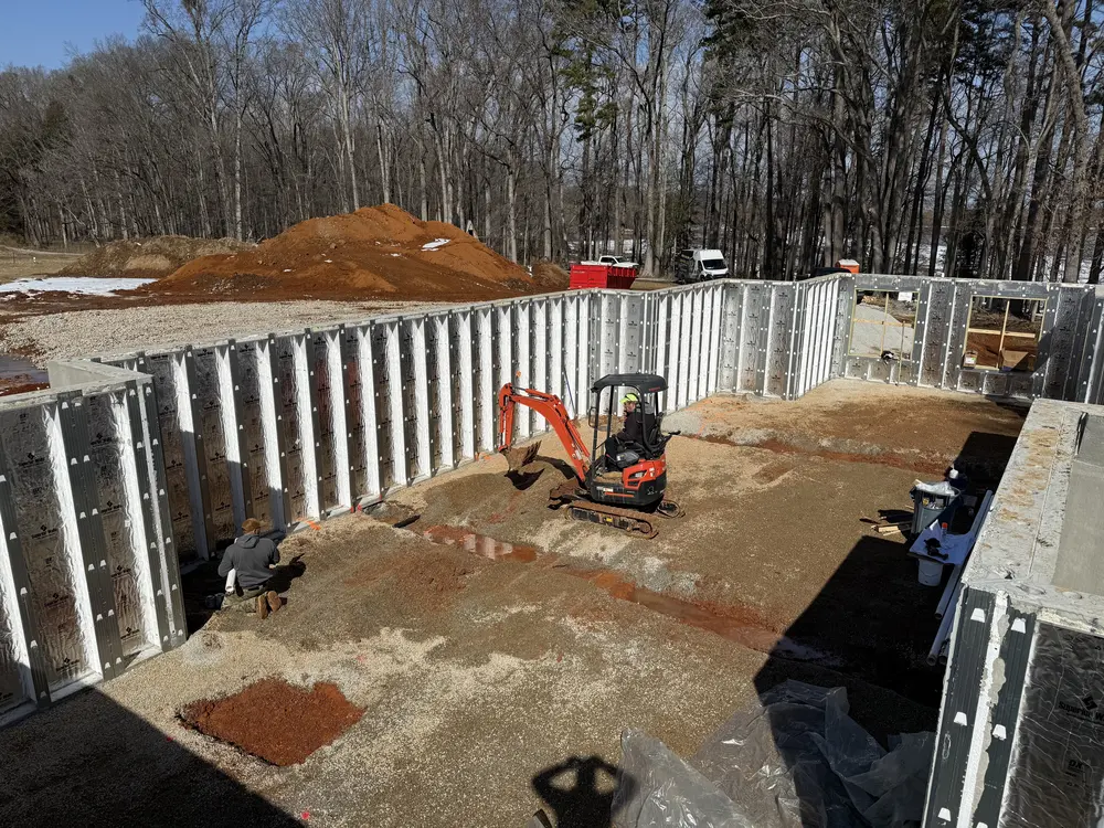 Under-slab plumbing work inside a new basement foundation