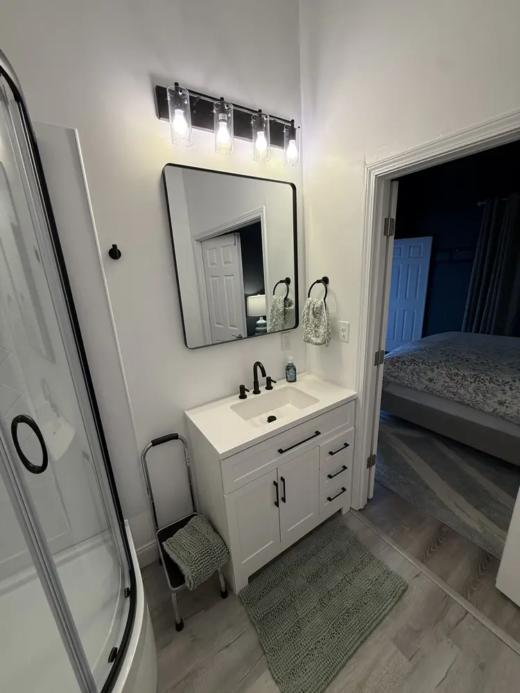 Bathroom vanity, faucet and corner shower