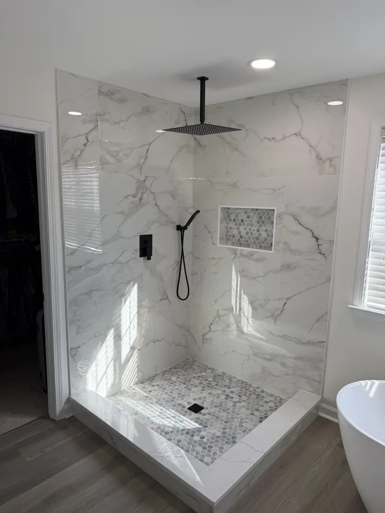 Walk-in shower with a ceiling rain head and handheld sprayer