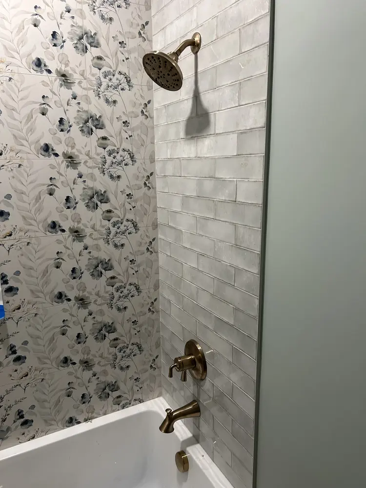 Tub and shower valve with brass trim in a newly tiled bathroom