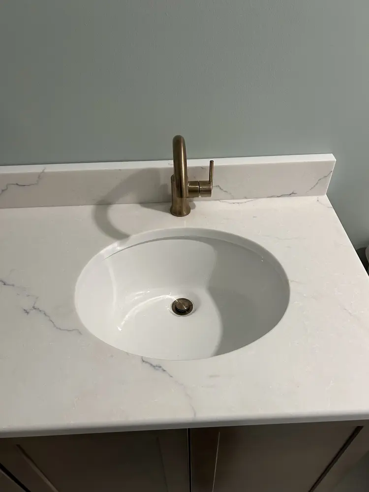 Gold single-handle faucet on a quartz vanity